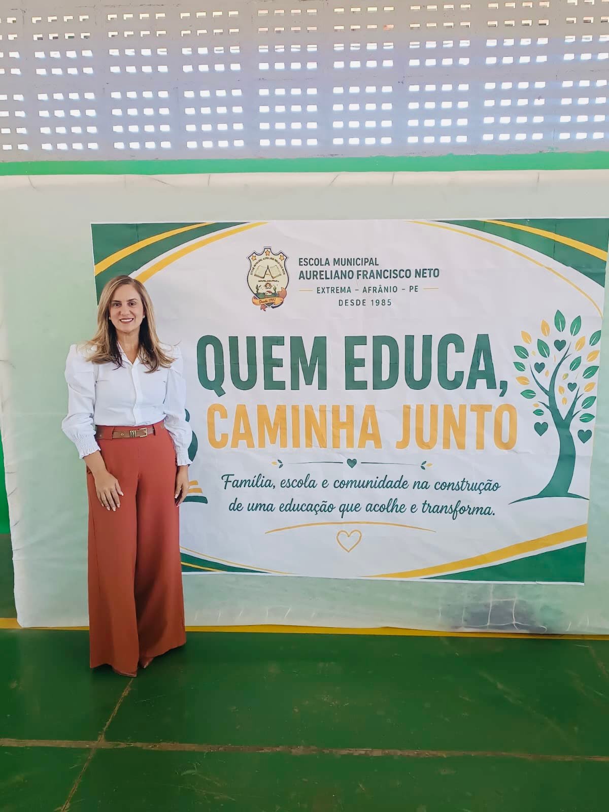 Taciana diante do painel sobre família, escola e comunidade